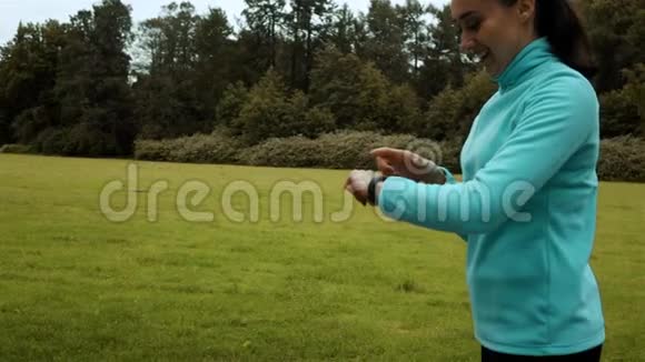 女性运动员使用智能手表健身手表视频的预览图