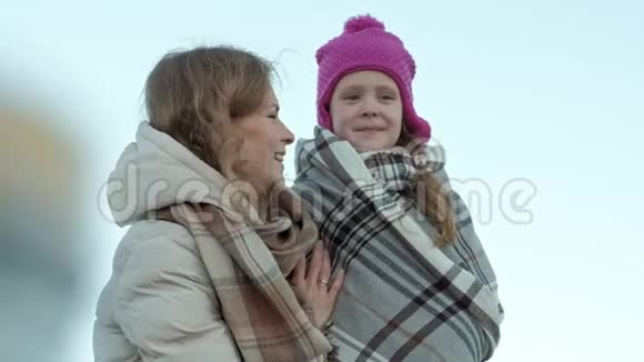 一个女人带着一个女孩一个母亲带着一个女儿站在河港上牵手拥抱微笑快乐视频的预览图