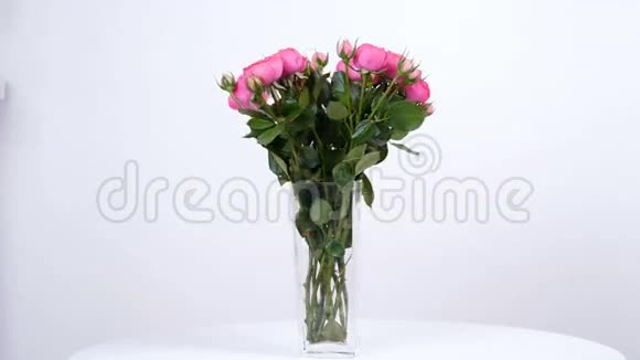 花花束在白色背景上旋转花的组成由粉红色玫瑰形组成视频的预览图