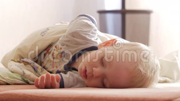 孩子躺在沙发上开始醒来他睁开眼睛用手揉搓眼睛视频的预览图