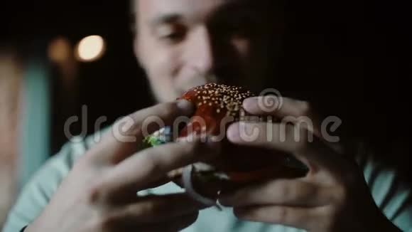 男人喜欢吃品尝美味的汉堡肉和奶酪和蔬菜视频的预览图
