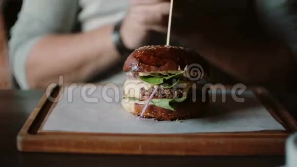 美味的汉堡在木制托盘上很棒一个人牵着手吃尝一尝视频的预览图