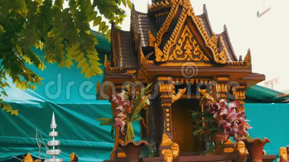 棕色的佛教小祭坛用花和各种雕像装饰在花园里祈祷视频的预览图