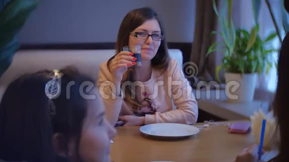 那个女人坐在咖啡馆里喝着一杯玻璃杯女人正在咖啡馆里吃一段慢动作视频视频的预览图