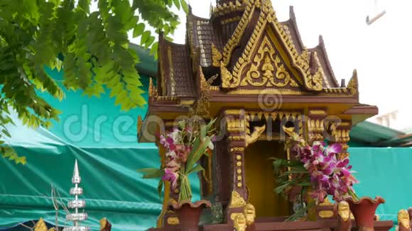 棕色的佛教小祭坛用花和各种雕像装饰在花园里祈祷视频的预览图