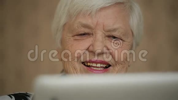微笑老妇人使用平板电脑视频的预览图