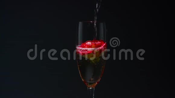 香槟被倒入带有玫瑰的玻璃杯中黑色背景关门视频的预览图