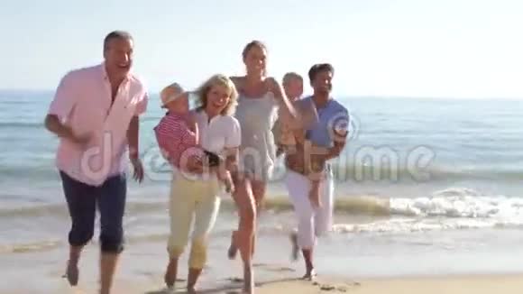 多代家庭沿着海滩跑步视频的预览图