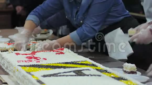 戴着白手套的女性手把蛋糕切成块送给购物中心的游客送给穷人糖果视频的预览图