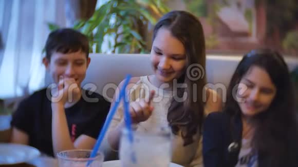 一群孩子在咖啡馆里喝奶昔青少年男孩孩子们在咖啡馆里呆着慢视频有趣的快乐视频的预览图