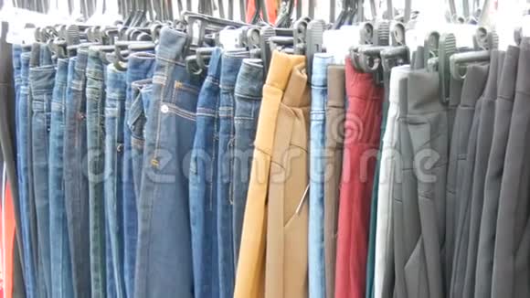 裤子挂在衣架上女人看衣服选择跳蚤市场市场上出售的衣服视频的预览图