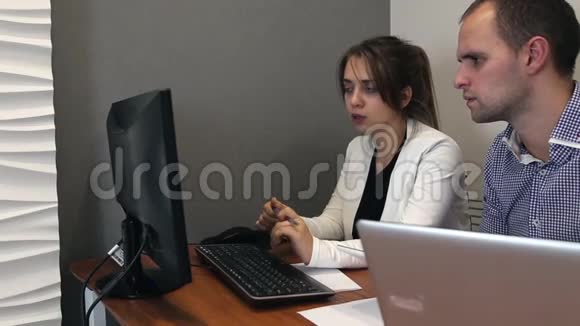 年轻人和女人正在电脑上工作视频的预览图