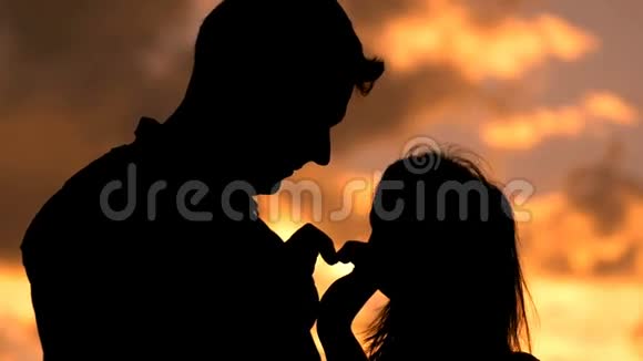 浪漫的年轻情侣用手侧影做心形视频的预览图