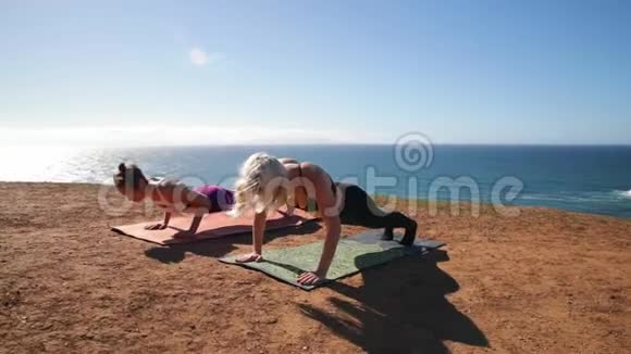 健身运动友谊和生活方式的概念运动妇女做瑜伽运动坐在阳光明媚的早晨的垫子上视频的预览图
