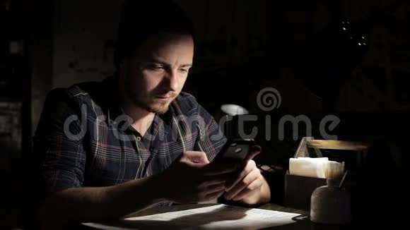 男人晚上在餐馆用智能手机视频的预览图