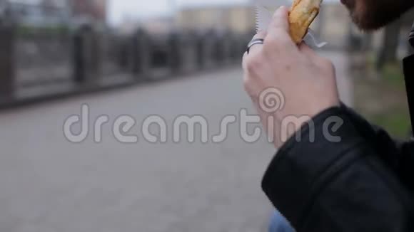 成年人独自一人坐在长椅上吃热狗视频的预览图