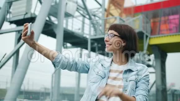幸福的年轻女人在外面用智能手机相机自拍的肖像视频的预览图