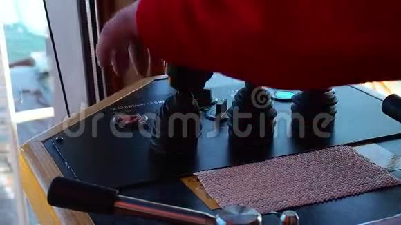 男子船桥上的一个红色连衣裙绞车控制杆特写镜头视频的预览图