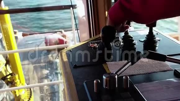 男子船桥上的一个红色连衣裙绞车控制杆特写镜头视频的预览图