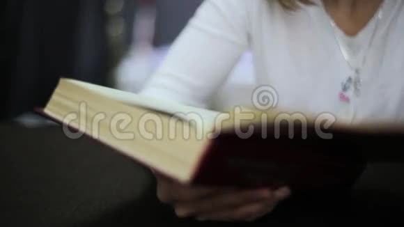 可爱的年轻女人看书书籍装订的特写视频的预览图