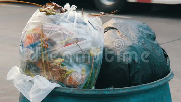 在繁忙的街道上满是堵塞的垃圾桶里面装着塑料袋剩饭剩菜和其他垃圾车和视频的预览图