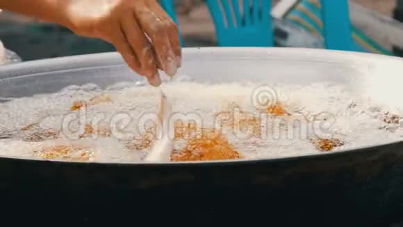 泰国和亚洲的街头食品一个大的煮沸的大桶女人用手烹调并放入鸡块小鸡视频的预览图