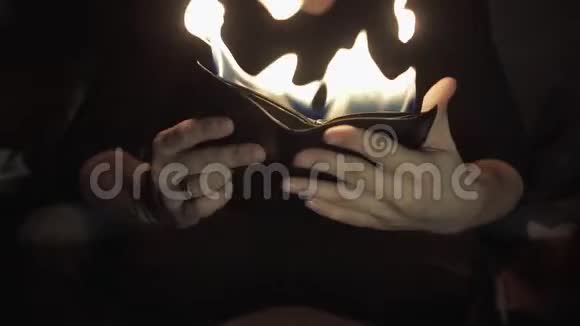 魔术师手里拿着一个燃烧的钱包视频的预览图