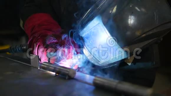 特写镜头焊工穿着防护服与金属焊接金属一起工作慢动作视频的预览图
