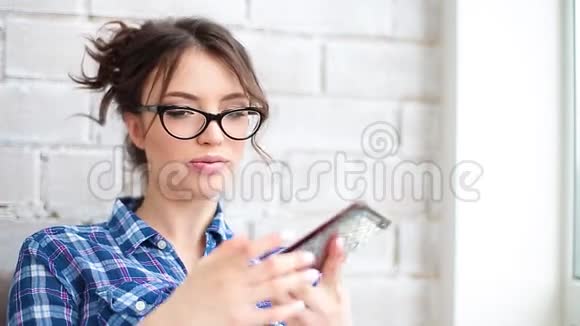 幸福的女人在家里的客厅里用手机说话视频的预览图