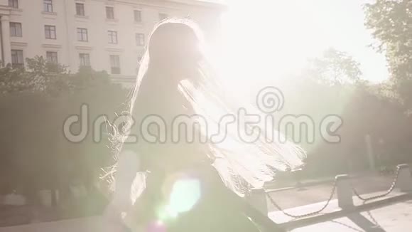 年轻漂亮的姜妹穿着绿色裙子在城市广场旋转视频的预览图