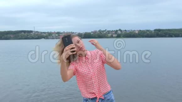 女人在湖边慢动作的手机上自拍视频的预览图