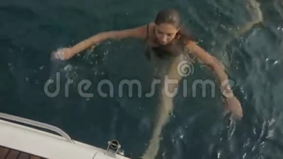湿漉漉的黑发女人游上船爬上船视频的预览图