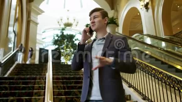 年轻人在梯子旁的室内手机上讲话视频的预览图