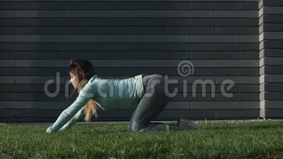 年轻女子在草地上从事健身活动视频的预览图