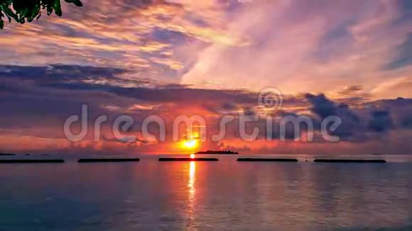 在马尔代夫的岛屿上五颜六色的日落在平稳的时间流逝橙色的天空乌云和地平线上的岛屿视频的预览图