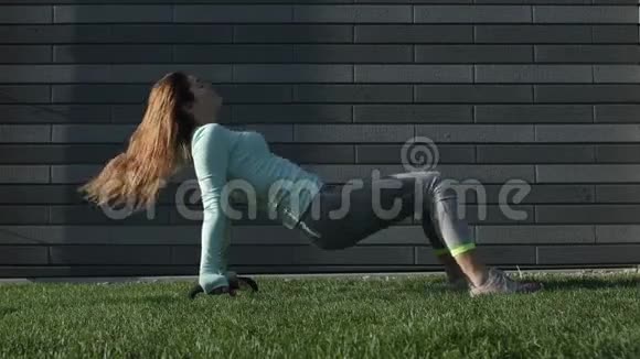 年轻女子在草地上从事健身活动视频的预览图