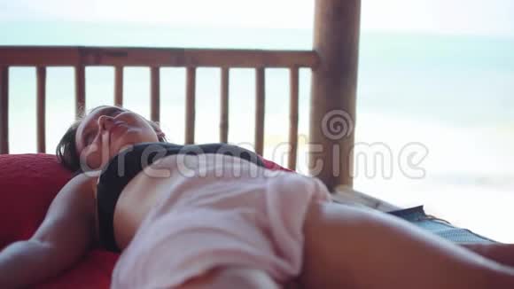 年轻快乐的女人躺在热带海滩上放松的水疗沙龙里按摩治疗师做腿部按摩关门视频的预览图