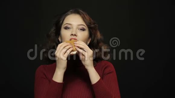 年轻女人吃汉堡包特写镜头视频的预览图