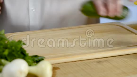 厨刀的手大厨房一根新鲜的绿色黄瓜从树上掉下来的砧板上视频的预览图