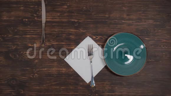 一个绿色的盘子用餐具在桌子上移动视频的预览图