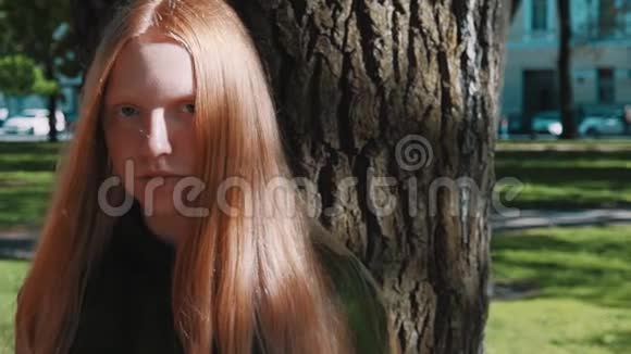 长发红发美女站在公园树下视频的预览图