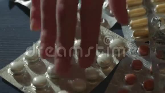 女人的手在桌子上吃不同的药丸制药医疗药物背景视频的预览图