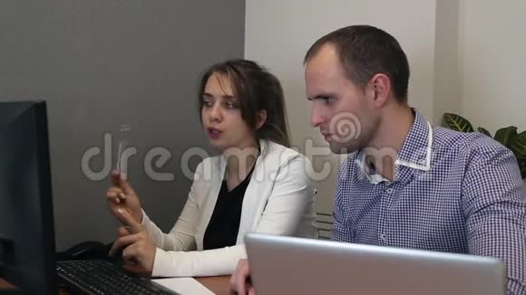 年轻人和女人正在电脑上工作视频的预览图