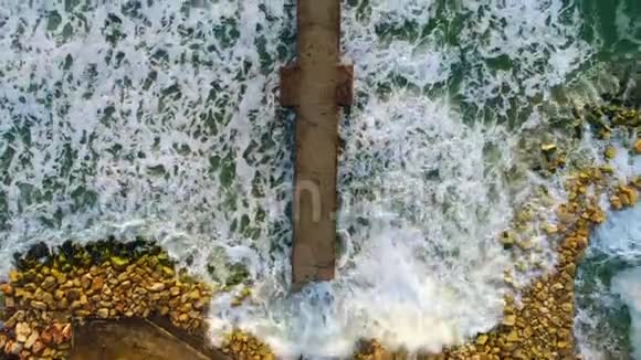 空中无人机观看海上美丽的日出海滩上的断桥视频的预览图