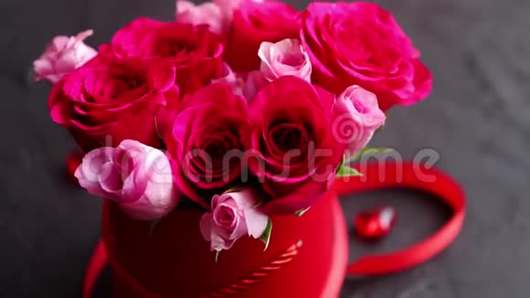 粉红色玫瑰花束装在红色盒子里放在黑色的石头背景上视频的预览图