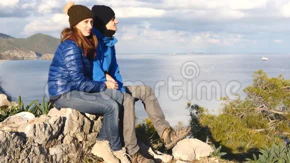 年轻夫妇坐在岩石的顶端视频的预览图