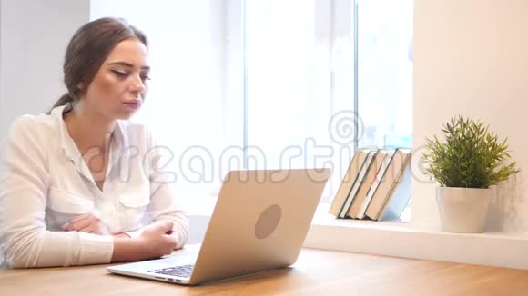 工作中的忧郁少女在笔记本电脑上工作视频的预览图