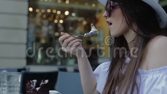 优雅的女人喜欢在街头咖啡馆吃甜食视频的预览图