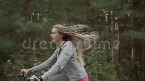 女孩骑自行车在郊区公路上视频的预览图