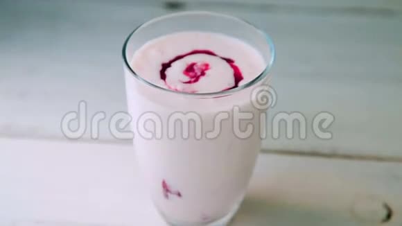 在透明玻璃中加入覆盆子果酱的现场酸奶视频的预览图
